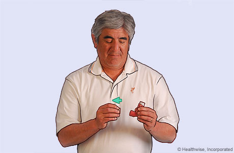 Picture of a man removing the cap from an inhaler