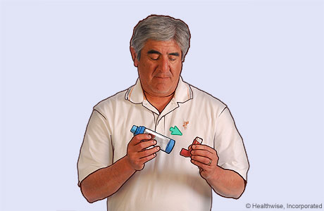 Picture of a man putting the inhaler mouthpiece into the spacer