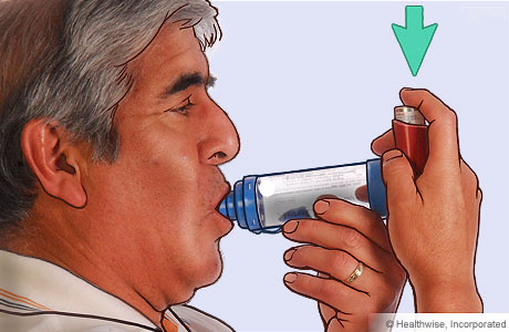 Picture of a man pressing down on the inhaler